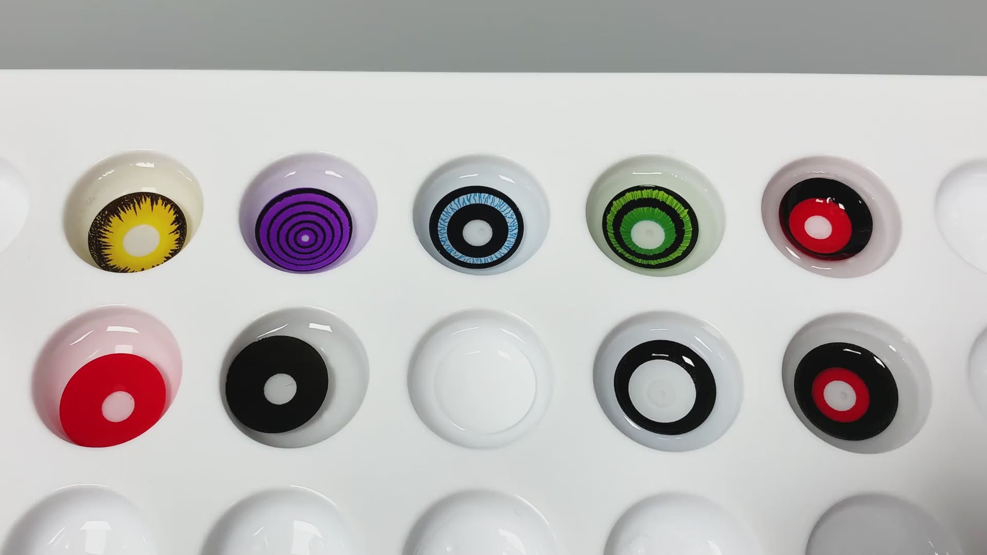 Product video presenting a range of Anime Sharingan Costume Contacts, featuring close-up views of the lenses in various shades and demonstrating how they appear when applied to the eyes.