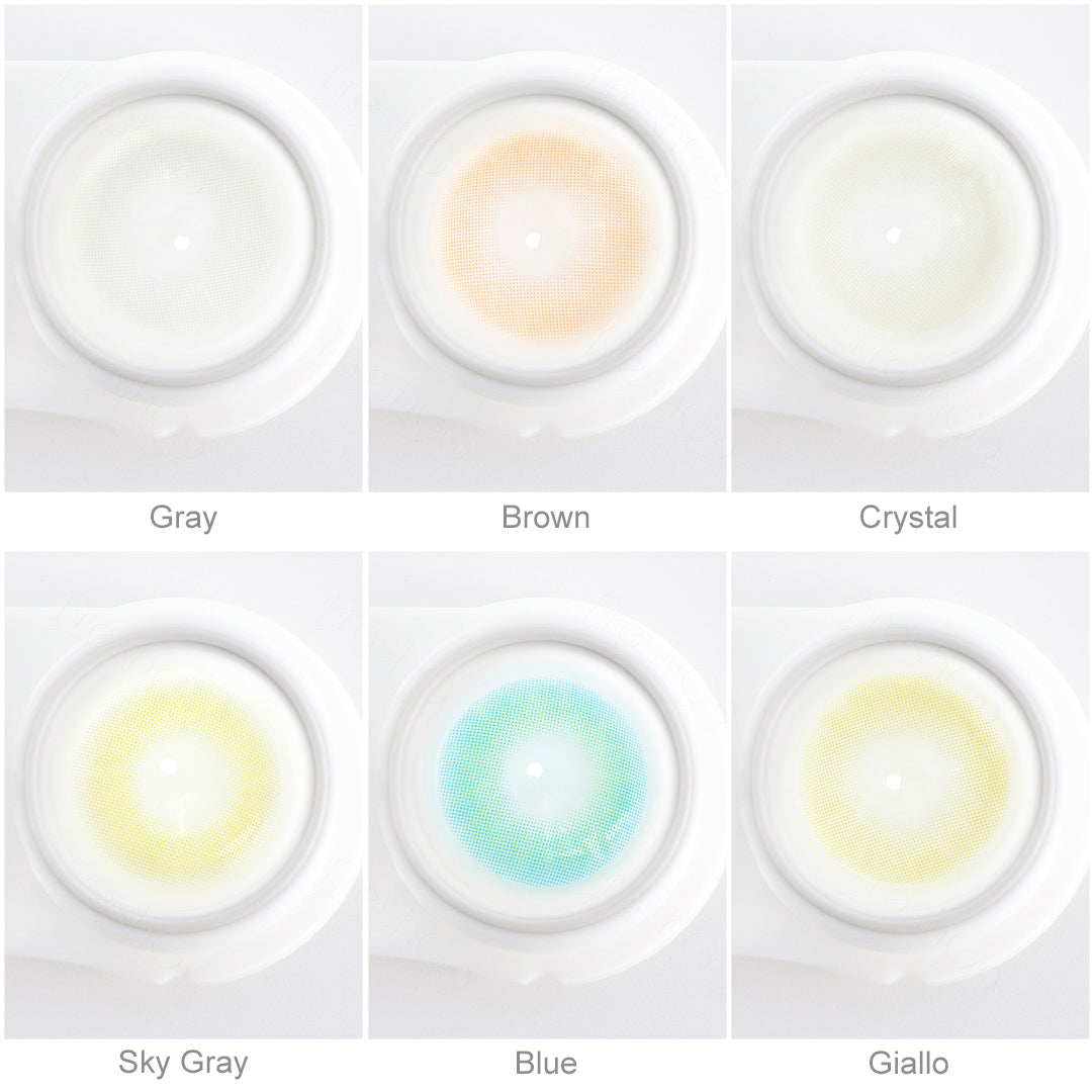 Array of HIDROCOR_II contact lenses in a white case, showcasing five colors:Gray,Crystal,Brown,Sky Gray,Blue,Giallo. Each lens is labeled with its color name beneath the case.